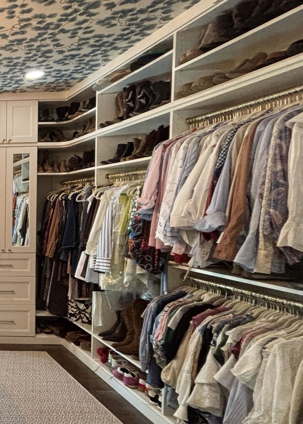 Double hanging rods and shoe shelves in a white walk-in closet